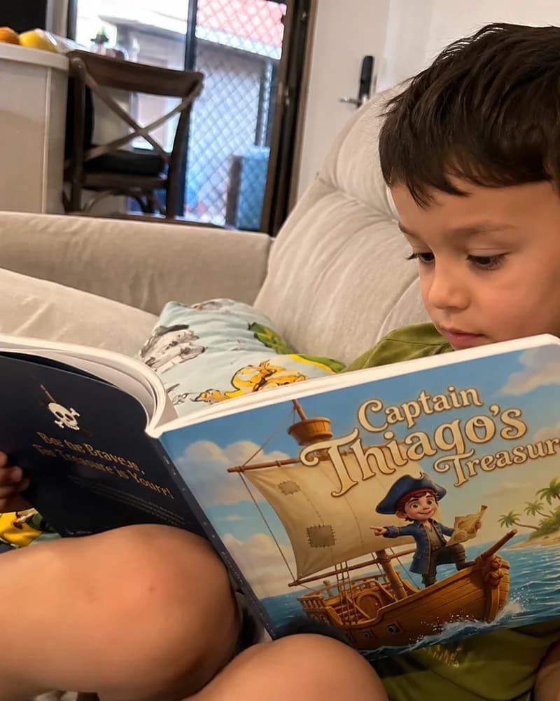 A boy curled into the corner of the couch, absorbed in his open pirate book.